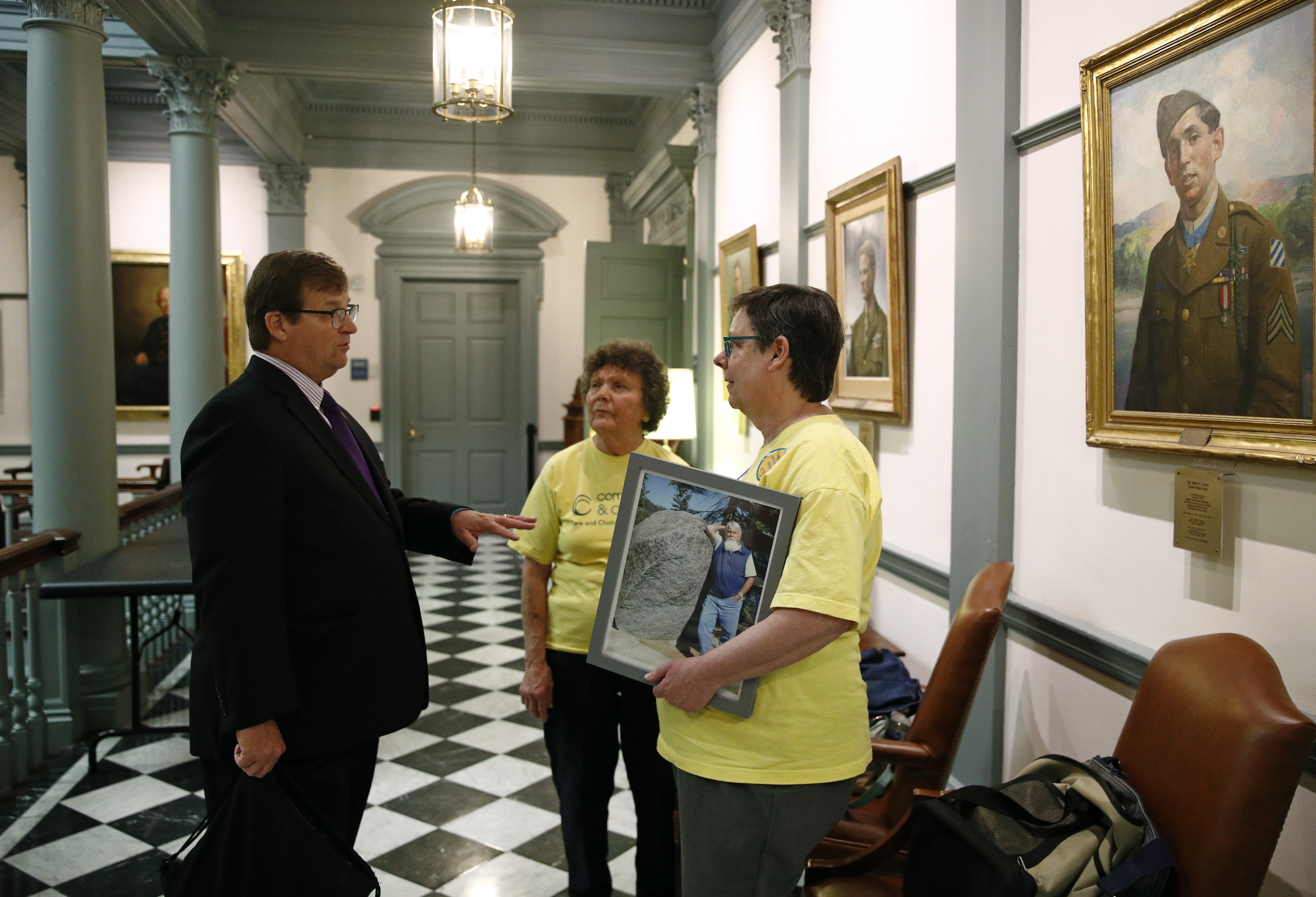 In this April 26 photo, David Humes, left, speaks with visitors inside Legislative Hall, the state capitol building, in Dover, Del. Humes, whose son died from a heroin overdose in 2012, has been pushing for an opioid tax in Delaware, which did not increase funding for addiction treatment in 2017 as it struggles to balance its budget. “When you think about the fact that each year more people are dying, if you leave the money the same, you’re not keeping up with this public health crisis,” he said. (AP Photo/Patrick Semansky)