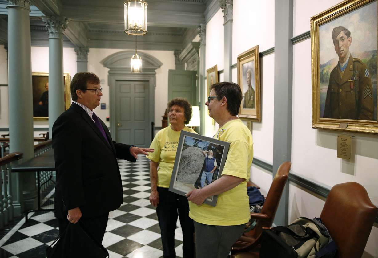 In this April 26 photo, David Humes, left, speaks with visitors inside Legislative Hall, the state capitol building, in Dover, Del. Humes, whose son died from a heroin overdose in 2012, has been pushing for an opioid tax in Delaware, which did not increase funding for addiction treatment in 2017 as it struggles to balance its budget. “When you think about the fact that each year more people are dying, if you leave the money the same, you’re not keeping up with this public health crisis,” he said. (AP Photo/Patrick Semansky)