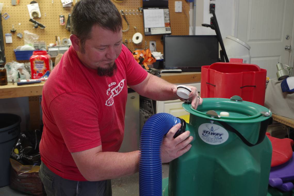 Nate Wilson demonstrates the 3-inch hose hookup for an RV dump on the Selway toilet. (Photo: Courtesy of Steve Stuebner)