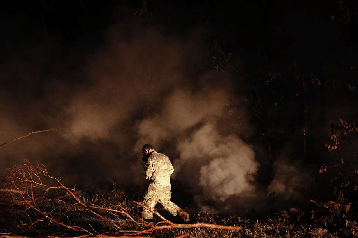Sgt. 1st Class Carl Satterwaite, of the U.S. National Guard, tests air quality near cracks emitting volcanic gases from a lava flow in the Leilani Estates subdivision near Pahoa, Hawaii Thursday, May 10, 2018. Kilauea has destroyed more than 35 structures since it began releasing lava from vents about 25 miles (40 kilometers) east of the summit crater. (Jae C. Hong, AP Photo)
