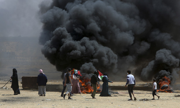 Palestinian protesters burn tires near the Israeli border fence, east of Khan Younis, in the Gaza Strip, Monday, May 14, 2018. Photo: AP Photo