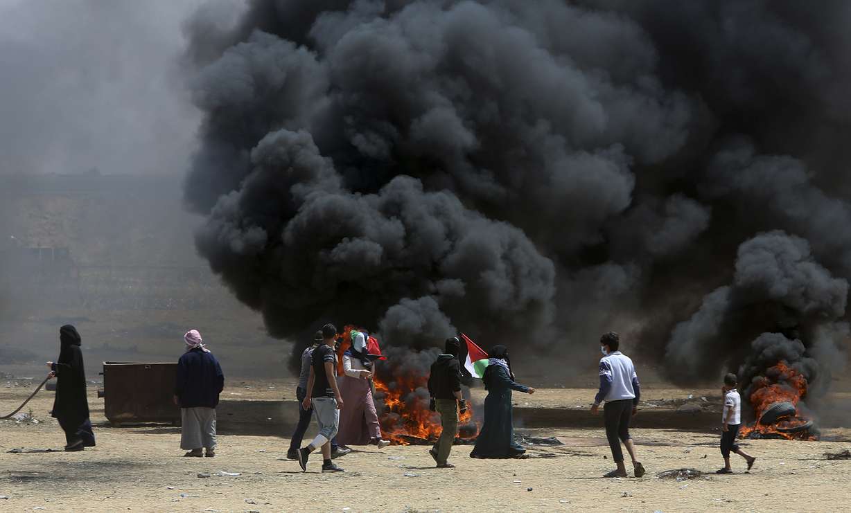 Palestinian protesters burn tires near the Israeli border fence, east of Khan Younis, in the Gaza Strip, Monday, May 14, 2018. Photo: AP Photo