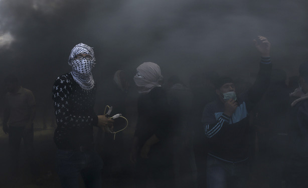 Palestinian protesters hurl stones at Israeli troops while engulfed in smoke from burning tires near the Gaza Strip's border with Israel, east of Khan Younis, in the Gaza Strip, Monday, May 14, 2018. Israeli fire has killed dozens of Palestinians during mass protests along the Gaza border, marking the deadliest day of violence since a devastating 2014 cross-border war and casting a pall over Israel's festive inauguration of the new U.S. Embassy in contested Jerusalem. (Adel Hana, AP Photo)