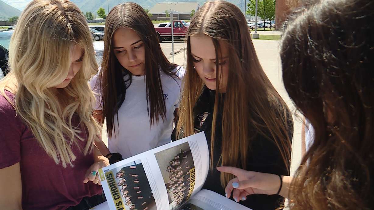Students look at a page in the Maple Mountain High School yearbook containing a word cloud in the shape of Springville High School's logo with words used to describe the rival Red Devils. (Photo: Mike DeBernardo, KSL TV)