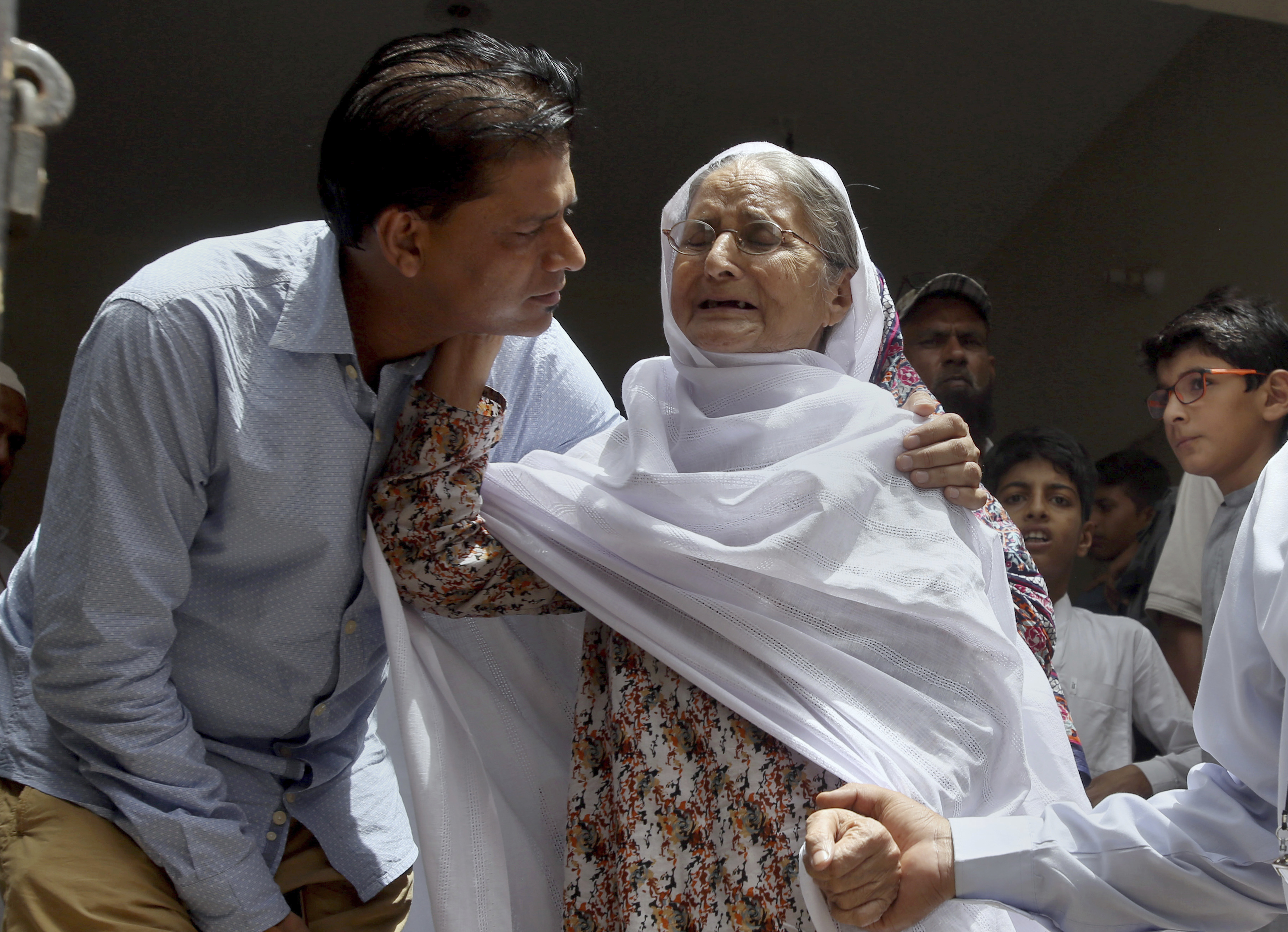 Abdul Aziz Sheikh, left, father of Sabika Sheikh, a victim of a shooting at a Texas high school, comforts to an elderly woman arriving for condolence to his daughter at his home in Karachi, Pakistan on Saturday. The Pakistani foreign exchange student is among those killed in the shooting, according to a leader at a program for foreign exchange students and the Pakistani Embassy in Washington, D.C. Megan Lysaght, manager of the Kennedy-Lugar Youth Exchange & Study Abroad program (YES), sent a letter to students in the program confirming that Sabika Sheikh was killed in the shooting. (AP Photo/Fareed Khan)