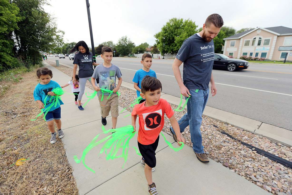 Chris and Yudinny Kitchen walk with their kids as they join Riverton community members gather to place ribbons along 12600 South on Sunday, May 27, 2018, in anticipation of welcoming home Josh Holt, who spent the last two years in a Venezuela prison and was released Saturday. (Photo: Scott G Winterton, KSL)