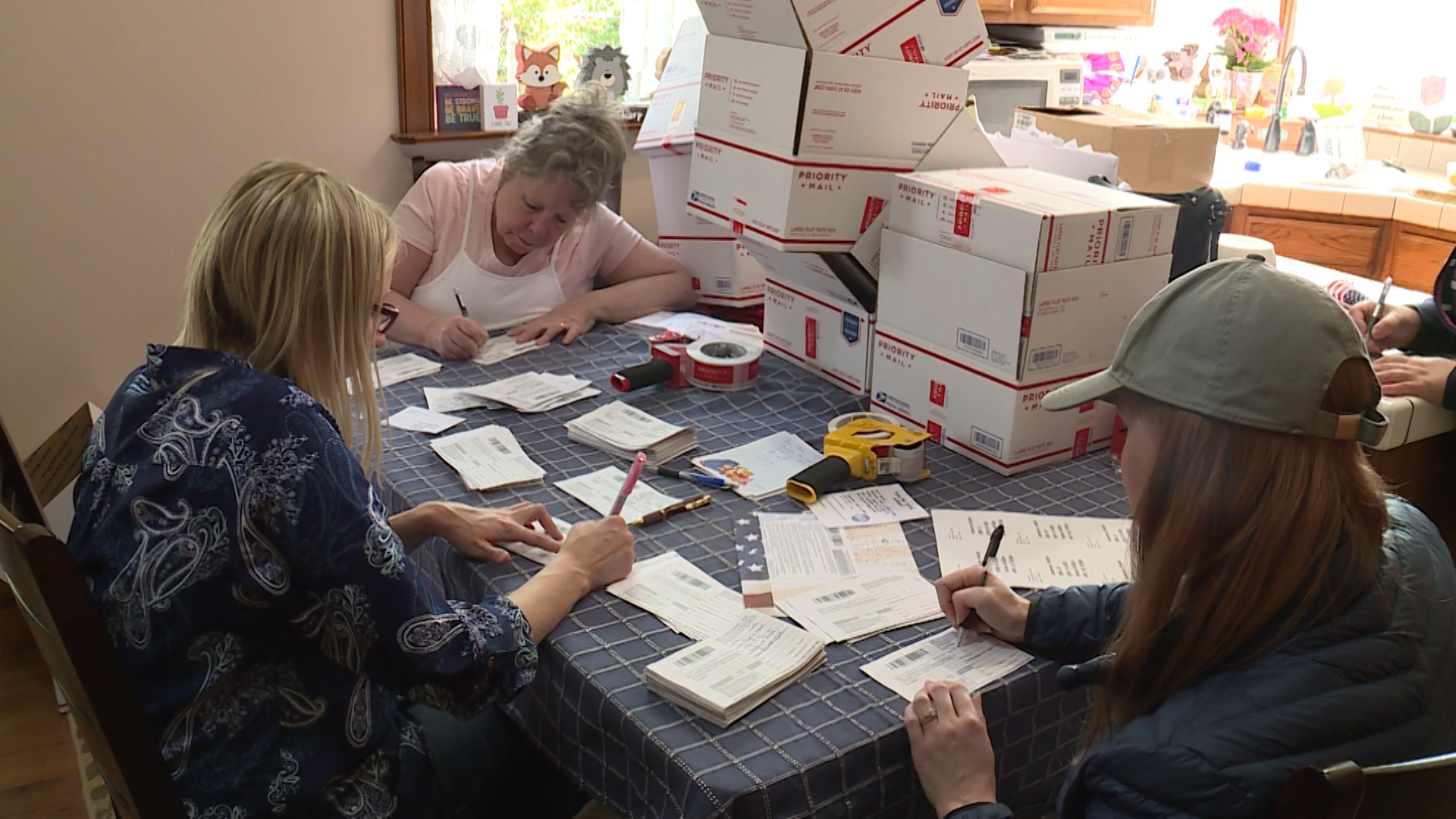Volunteers fill out forms at a table in Linda Larsen’s home on May 22, 2018. (Photo: Ray Boone, KSL TV)