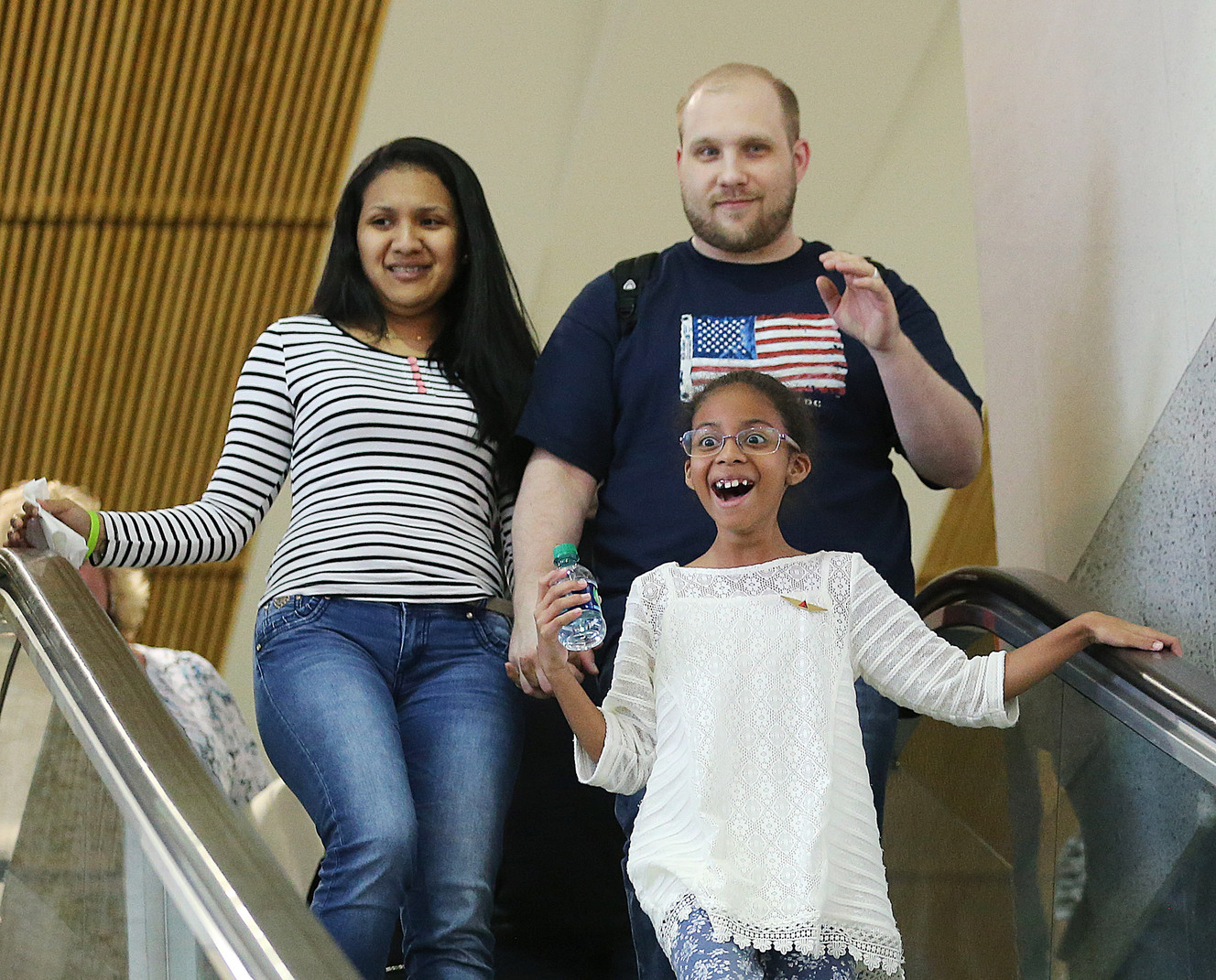 Josh Holt and his wife Thamy and her daughter Marian Leal react as family and friends cheer as they arrive at the International Terminal in Salt Lake City International Airport on Monday, May 28, 2018. (Photo: Scott G Winterton, KSL)