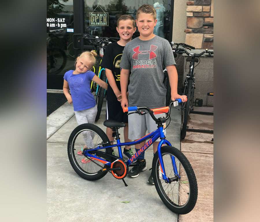 Evan Jones (far right) and his siblings picked out a bike with Nick’s favorite colors, orange and blue. (Photo: Courtesy Candace Jones)