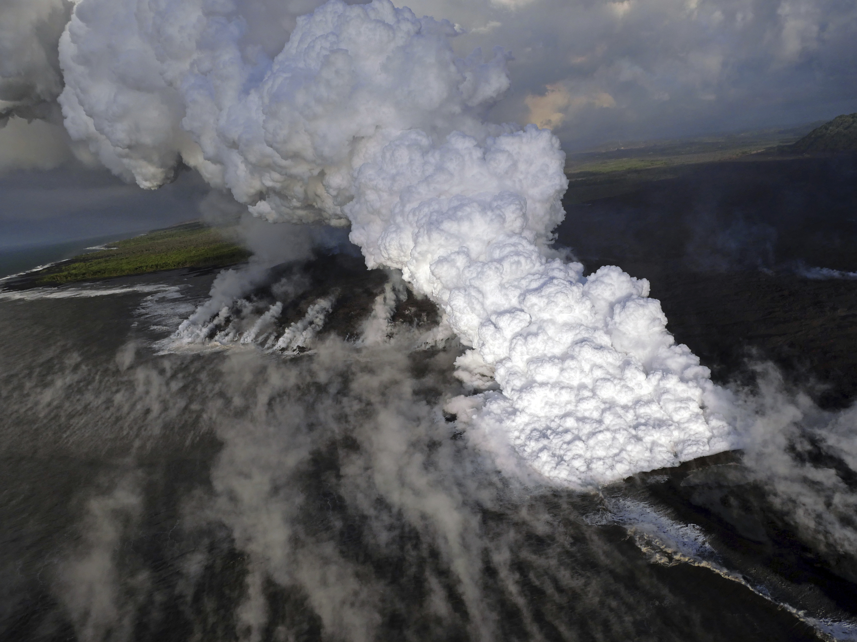 This Wednesday, June 6, 2018 photo from the U.S. Geological Survey shows a laze (lava haze) plume rising from the northern side of the fissure 8 lava flow margins in the former Kapoho Bay at the town of Kapoho on the island of Hawaii. As of 6:00 a.m. HST on June 6, this part of the flow front was slowly advancing through the remaining sections of the Kapoho Beach Lots subdivision. (U.S. Geological Survey via AP)