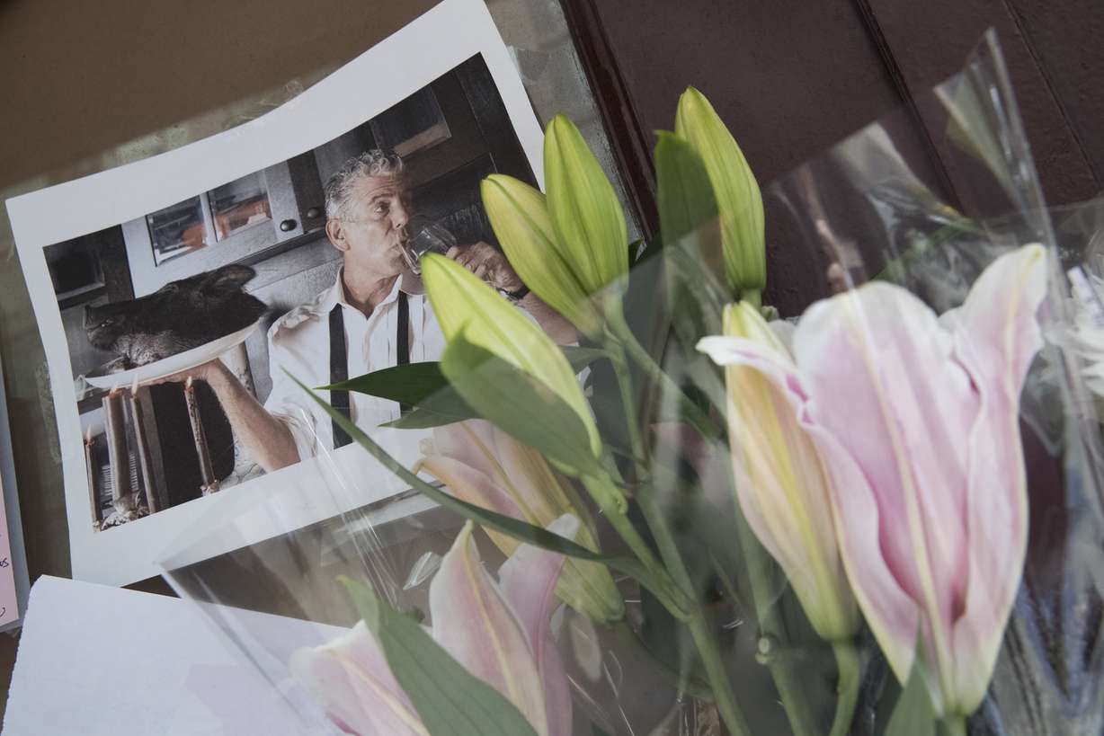 Flowers and a photo of Anthony Bourdain are seen at a make shift memorial outside the building that once housed Le Halles restaurant on Park Avenue, Friday, June 8, 2018, in New York. Bourdain, the celebrity chef and citizen of the world who inspired millions to share his delight in food and the bonds it created, was found dead Friday in his hotel room in France while working on his CNN series on culinary traditions. He was 61. (AP Photo/Mary Altaffer)