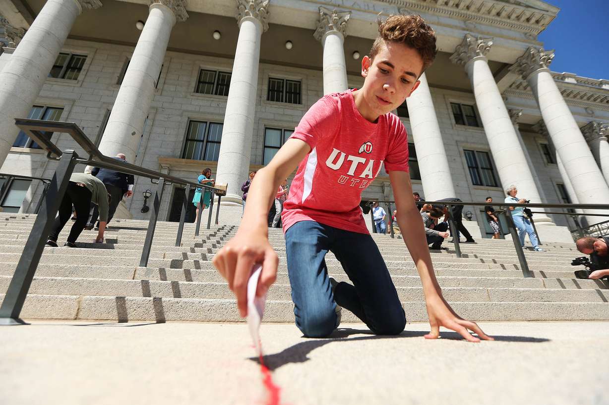 Preston Palmer of Backyard Broadcast, a youth based organization that brings awareness to sex trafficking, joins Rep. Angela Romero, D-Salt Lake City, the National Foundation for Women Legislators, the Junior League of Salt Lake City and the Utah Attorney General's Office on National Children's Day to raise awareness about Utah efforts to combat human trafficking on Sunday, June 10, 2018. (Photo: Scott G Winterton, KSL)