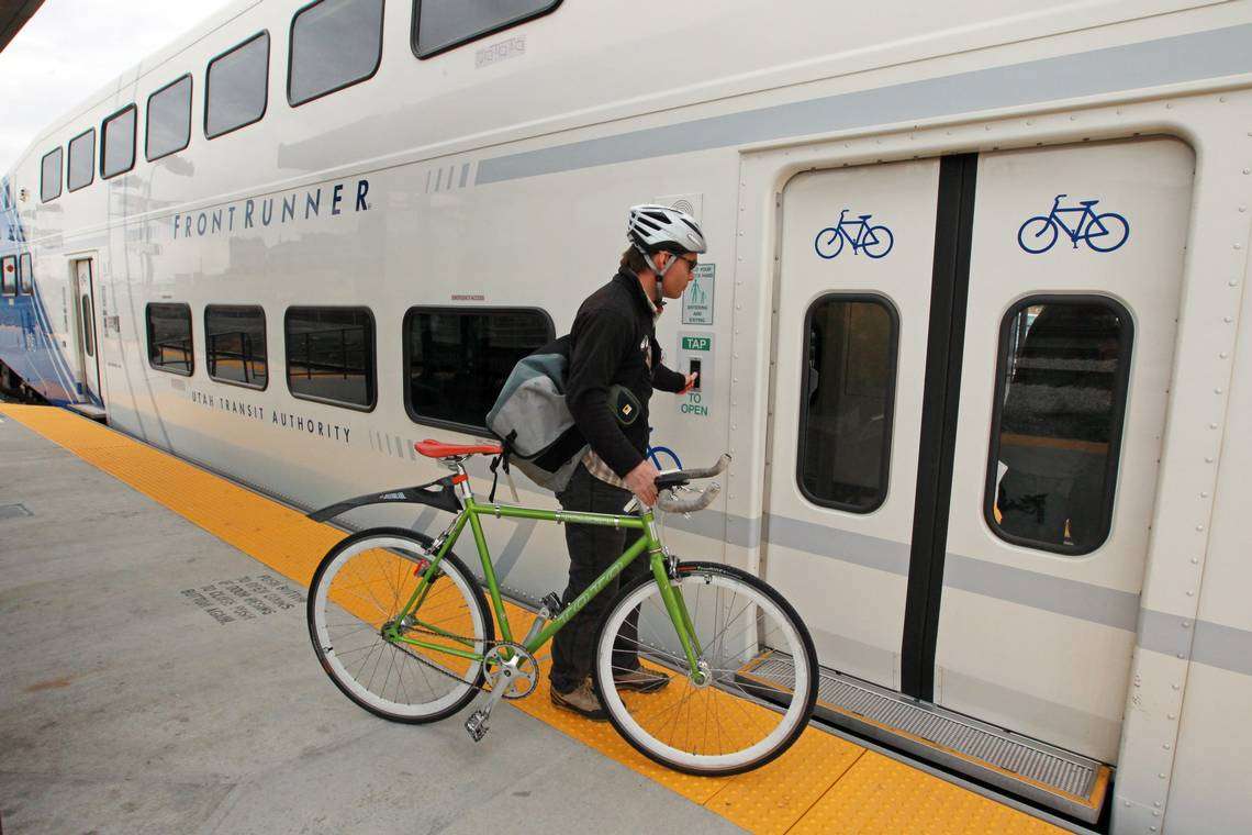 A commuter taps a button to board the Utah Transit Authority's "Frontrunner'" train after it arrives at a Salt Lake City station from Ogden. Ridership on the authority's commuter rail lines increased by 103 percent in 2013 after a new 45-mile rail line from Salt Lake City to Provo opened in late 2012. (Photo: Rick Bowmer, AP Photo, File)