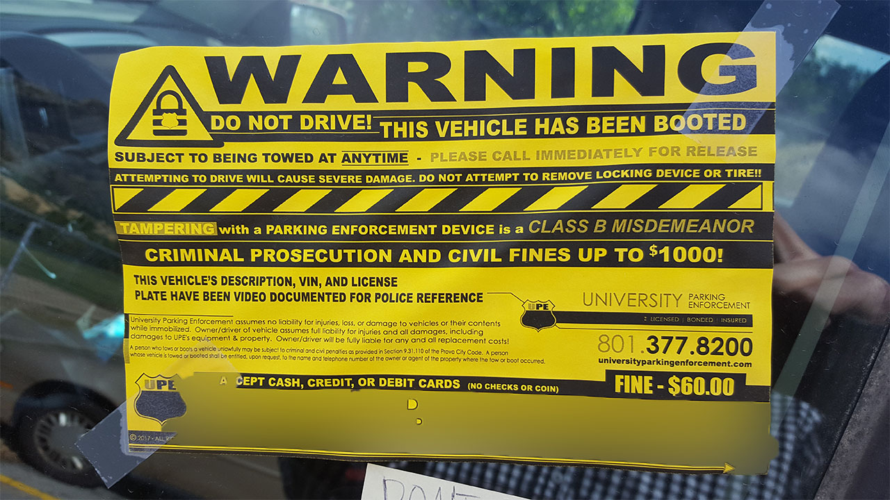 University Parking Enforcement's warning sign taped to a booted car. Photo courtesy of Carl Prince.