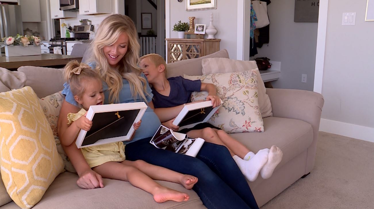 Linsday Lee sits with her two kids, Dax and Ava, as they look at old baby photos and ultrasound photos of their little sister due in September. (Photo: KSL TV)
