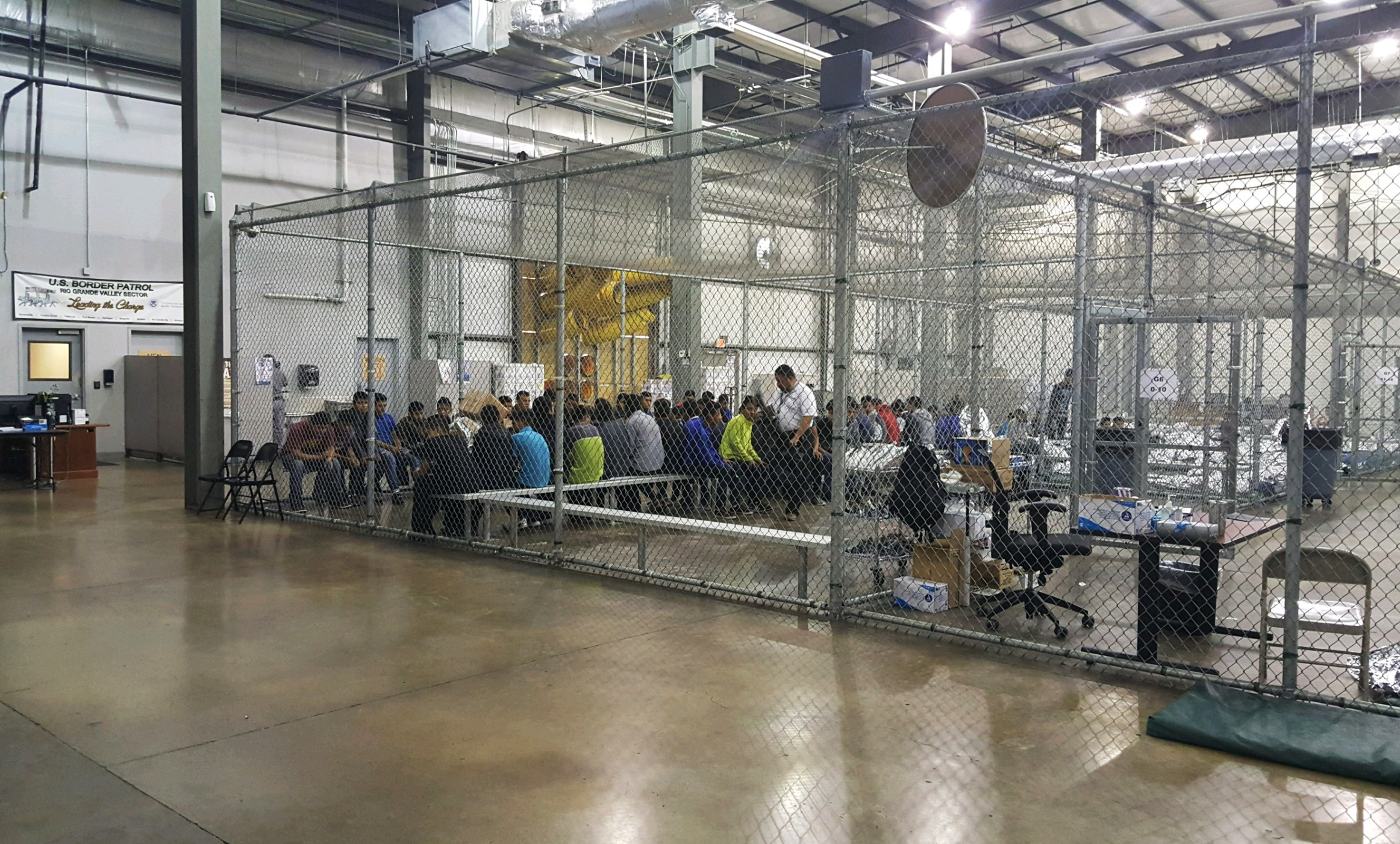People who've been taken into custody related to cases of illegal entry into the United States sit in one of the cages at a facility in McAllen, Texas, Sunday, June 17, 2018. Photo: U.S. Customs and Border Protection via AP