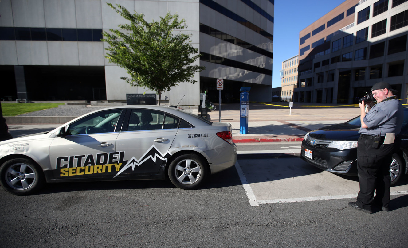 A crime scene photographer takes photos of a Citadel Security vehicle at the scene of a fatal shooting, involving a Citadel Security guard, between the Heber M. Wells Building and the Olene S. Walker Building in Salt Lake City on Wednesday, June 20, 2018. (Photo: Kristin Murphy, KSL)