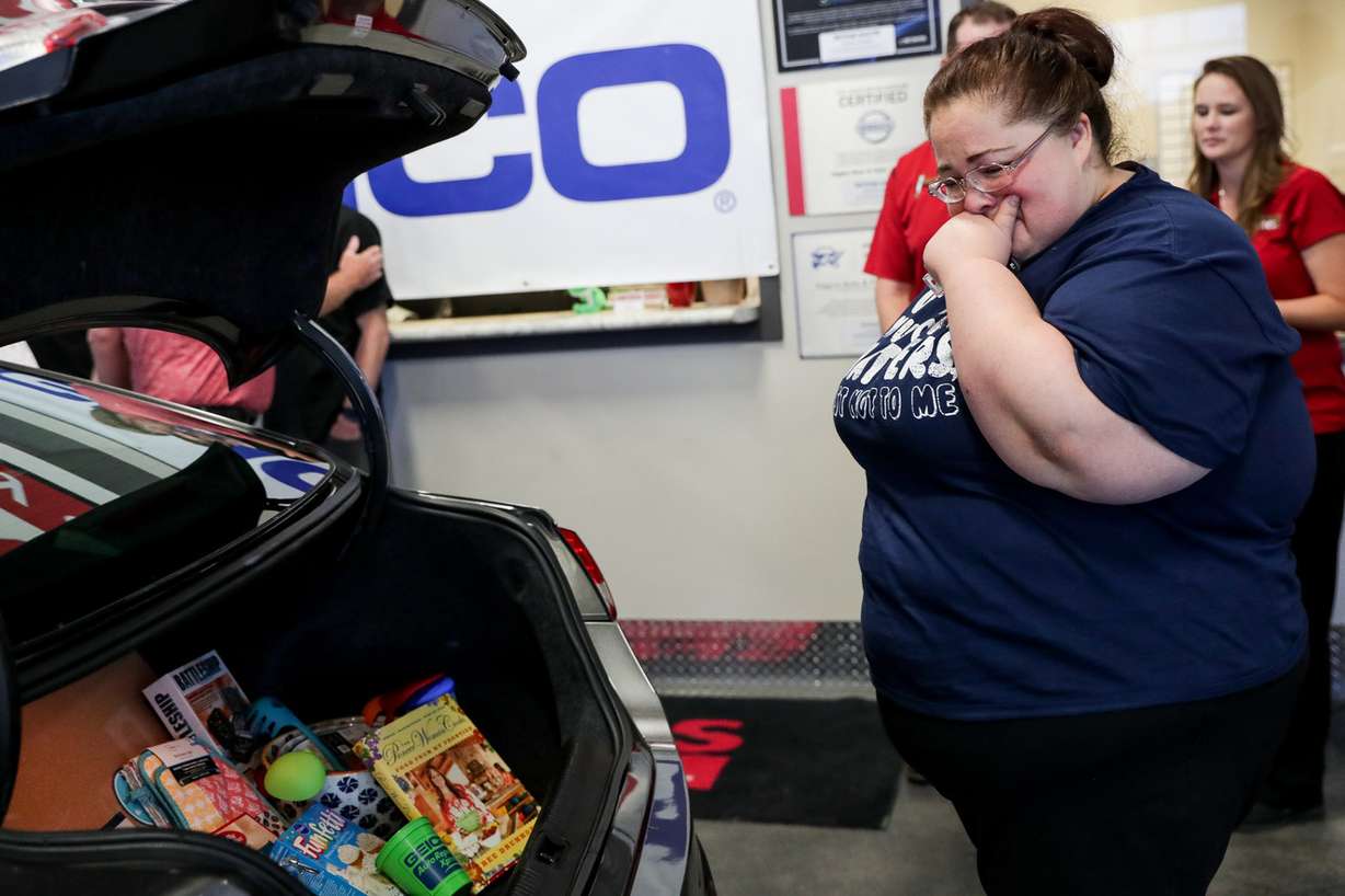 Darlene Lefevre looks at donated goods in the trunk of a 2015 Chrysler 200 that was given to her at Higgins Body and Paint in West Valley City on Wednesday, June 27, 2018. Geico and Higgins Body and Paint, along with other organizations, teamed up to donate a refurbished car to Lefevre and her daughter, who just moved out of a shelter and into an apartment a week ago. (Photo: Spenser Heaps, KSL)