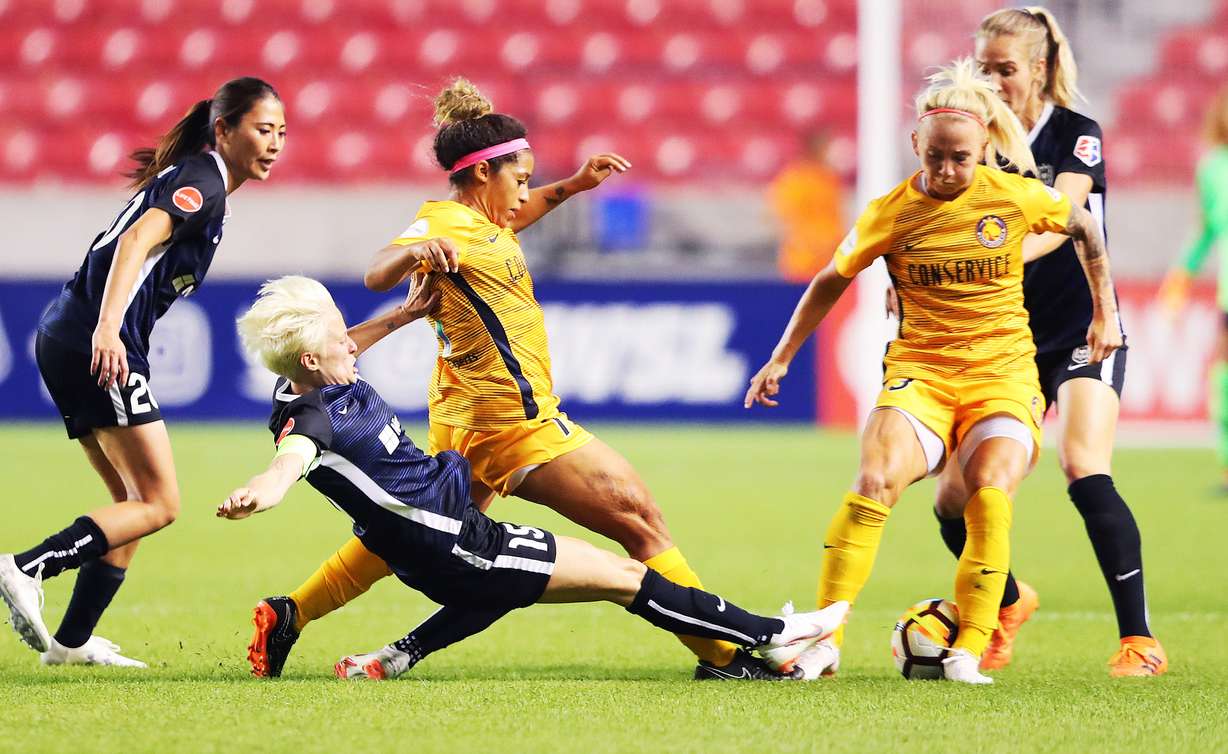 Seattle Reign FC forward Megan Rapinoe (15) slides into Utah Royals FC midfielder Desiree Scott (11) and Utah Royals FC midfielder Gunnhildur Jónsdóttir (23) as the Utah Royals and the Seattle Reign play at Rio Tinto Stadium in Sandy on Wednesday, June 27, 2018. (Photo: Scott G Winterton, Deseret News)