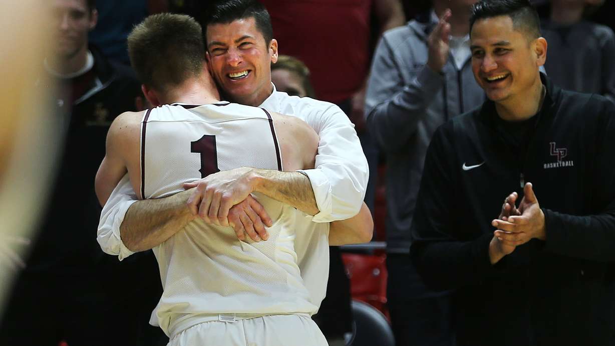 Lone Peak Head Coach David Evans hugs Max Brenchley as he comes out of the game as the Knights defeat Pleasant Grove in the 6A basketball championship in the Jon M. Huntsman Center at the University of Utah on Saturday, March 3, 2018.