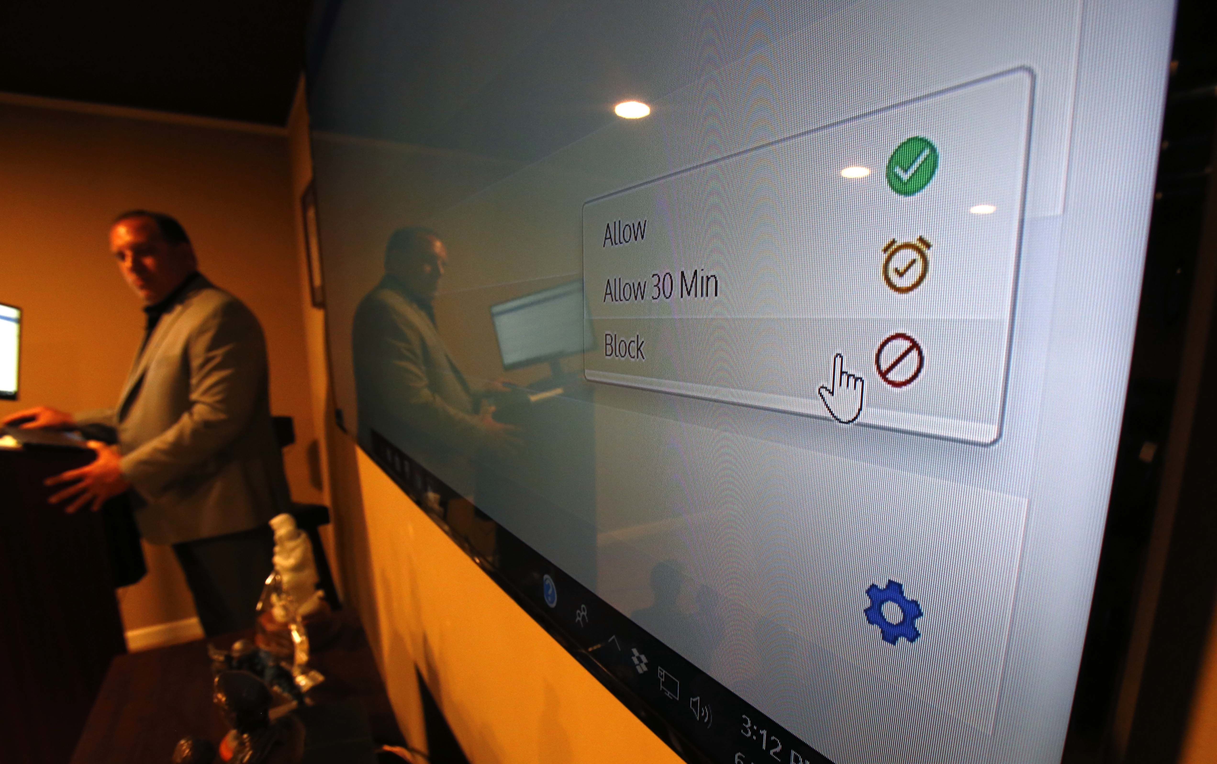 Rich Wistocki, a retired cybercrime detective who now consults with and trains educators, parents, kids and law enforcement on digital safety, demonstrates a parental monitoring app at his webcasting studio in Lockport, Illinois, on Tuesday, June 5, 2018. Wistocki, now head of Be Sure Consulting, says all parents should put monitoring apps on their kids' phones. The apps allow parents to monitor activity, approve apps and track their kids' location. (AP Photo/Martha Irvine)