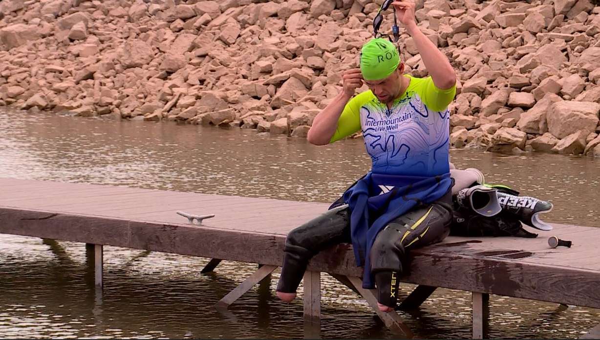 Sidney Smith sits on the dock after swimming with his training buddy in preparation for their first full Ironman Triathlon. (Photo: KSL TV)