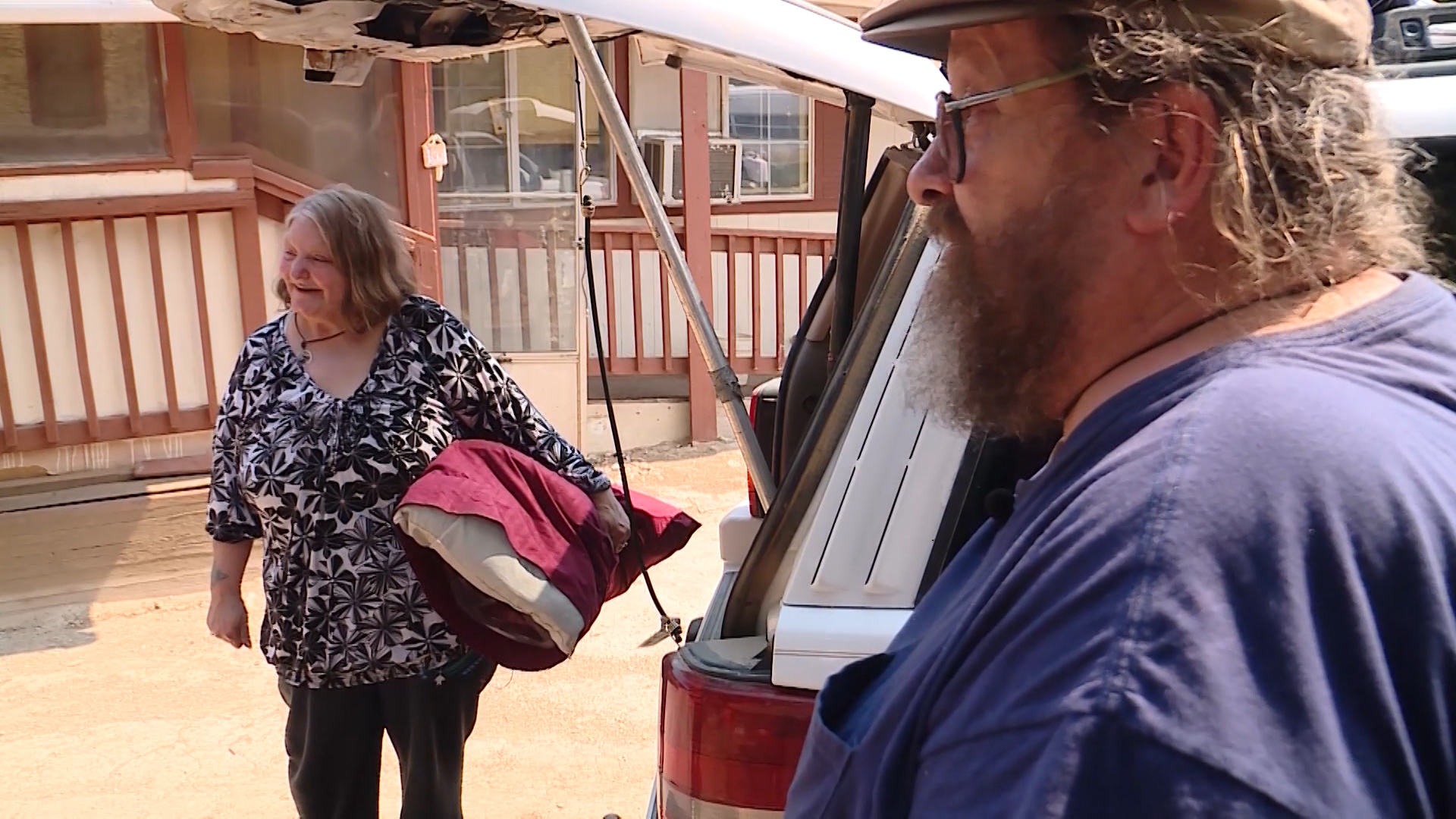 Charlie and Gigi Nay gather their belongings from their car as they prepare to return to their home on Saturday, July 7, 2018, after a mandatory evacuation due to the Dollar Ridge Fire was lifted. (Photo: Mike DeBernardo, KSL TV)