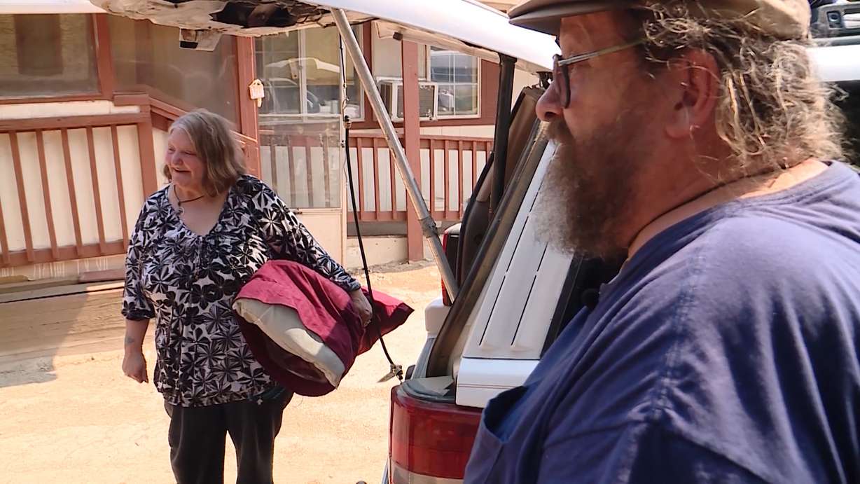 Charlie and Gigi Nay gather their belongings from their car as they prepare to return to their home on Saturday, July 7, 2018, after a mandatory evacuation due to the Dollar Ridge Fire was lifted. (Photo: Mike DeBernardo, KSL TV)