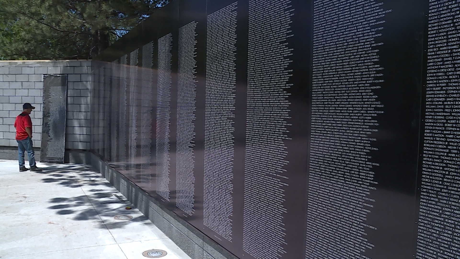 Dennis Howland, president of Vietnam Veterans of America, reads the names of those who died in the Vietnam War from a slab of Layton's new Vietnam War Memorial replica on Monday, July 9, 2018. Volunteers were finishing up the project this week before Saturday's dedication ceremony. (Photo: KSL TV)