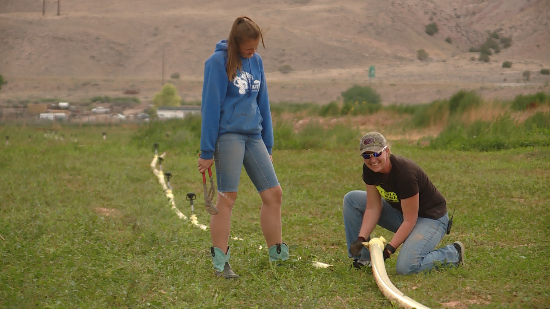 Janelle Turner, a neighbor to the Harris family, kneels while helping Tuesday, July 17, 2018. Photo: KSL TV