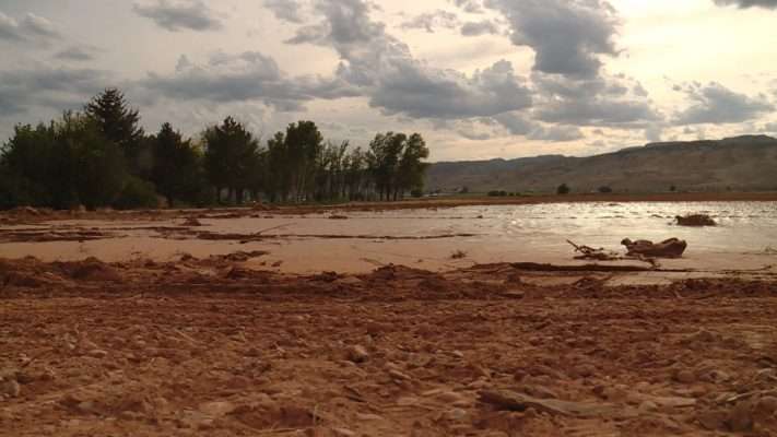 Rain water fills canals with boulders and buries about 90 percent of Kirk Harris's sod crops in mud and silt Tuesday, July 17, 2018. In some places, the mud was 3 feet deep. Photo: KSL TV
