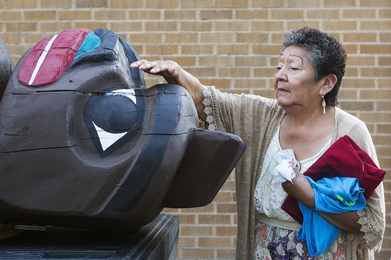 Mary Yazzie reaches to rest her hand on a bear totem at the Urban Indian Center in Salt Lake City on Thursday, July 19, 2018. The Lummi Nation is gifting the 9-foot tall bear totem to the Bear Ears Inter-Tribal Coalition to show support for the restoration of Bear Ears National Monument. It is believed to bless those who touch it. (Photo: James Wooldridge, KSL)