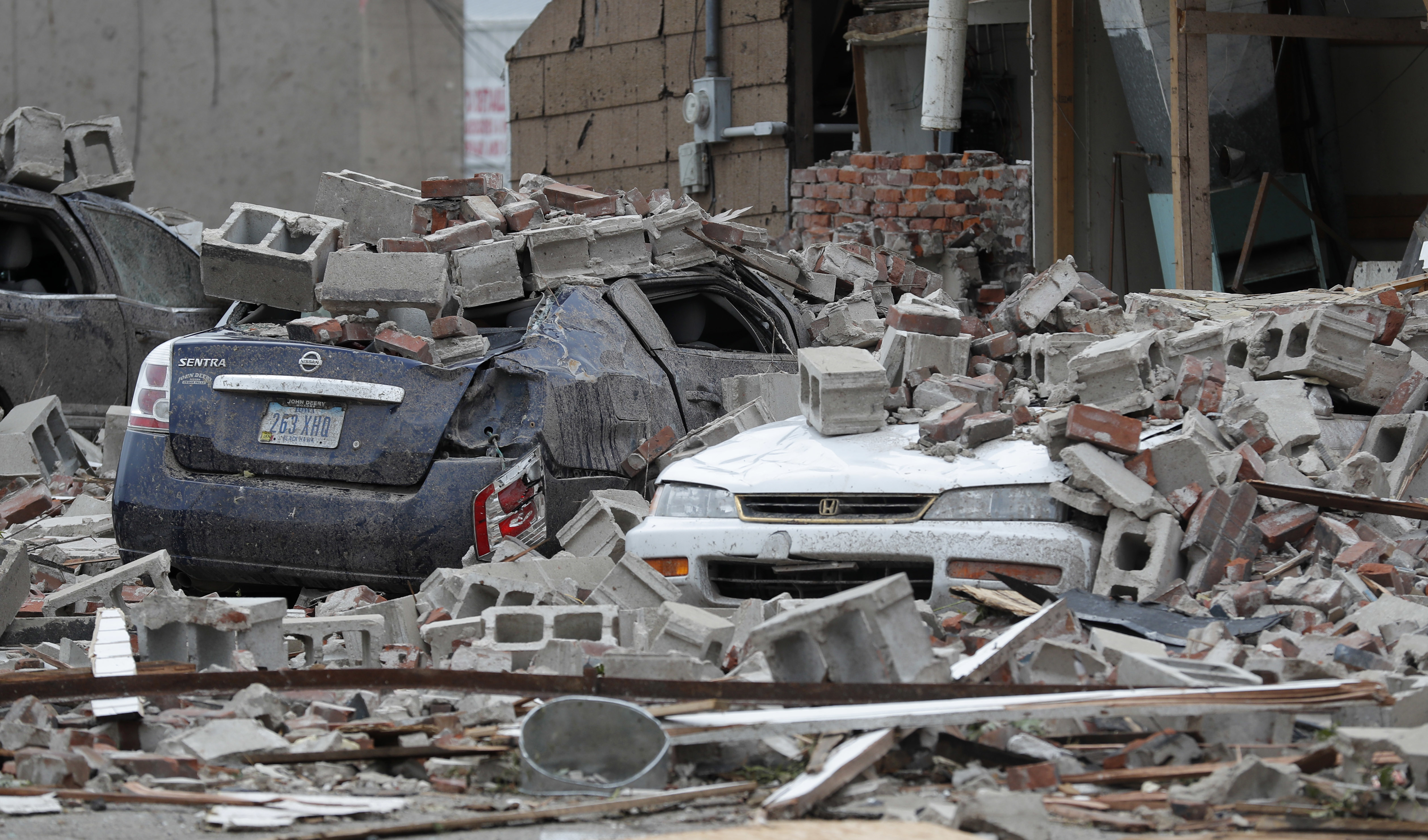 Vehicles are covered in rubble from a tornado damaged building, Friday, July 20, 2018, in Marshalltown, Iowa. Several buildings were damaged Thursday evening by a tornado in the main business district in town including the historic courthouse. (AP Photo/Charlie Neibergall)