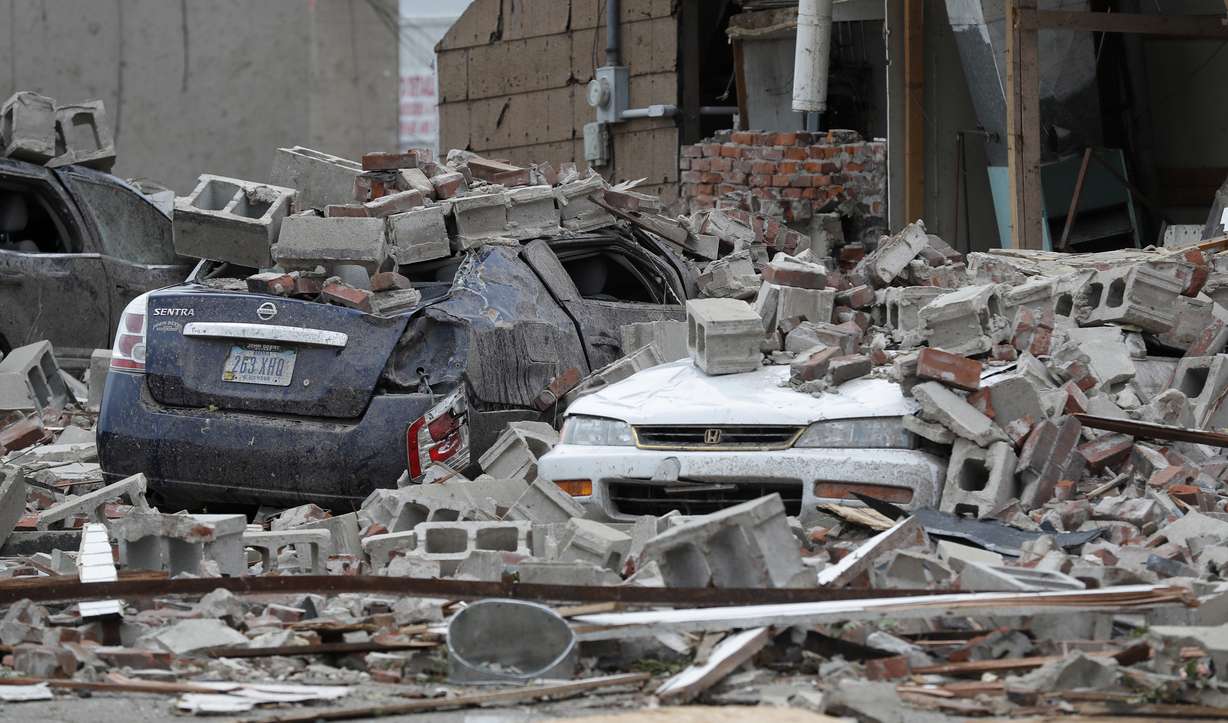 Vehicles are covered in rubble from a tornado damaged building, Friday, July 20, 2018, in Marshalltown, Iowa. Several buildings were damaged Thursday evening by a tornado in the main business district in town including the historic courthouse. (AP Photo/Charlie Neibergall)
