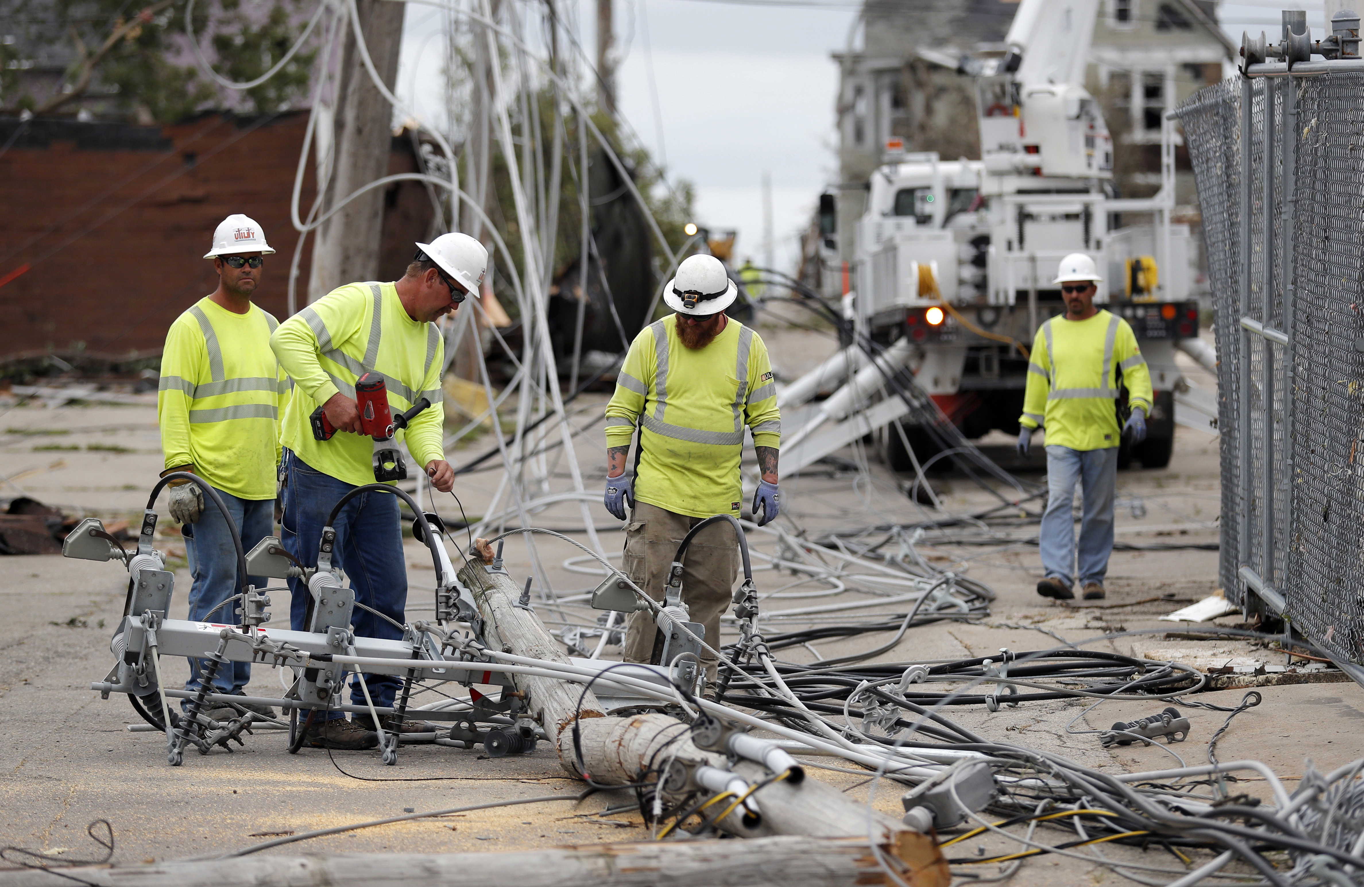 Utility workers repair downed power lines, Friday, July 20, 2018, in Marshalltown, Iowa. Several buildings were damaged Thursday evening by a tornado in the main business district in town including the historic courthouse. (AP Photo/Charlie Neibergall)