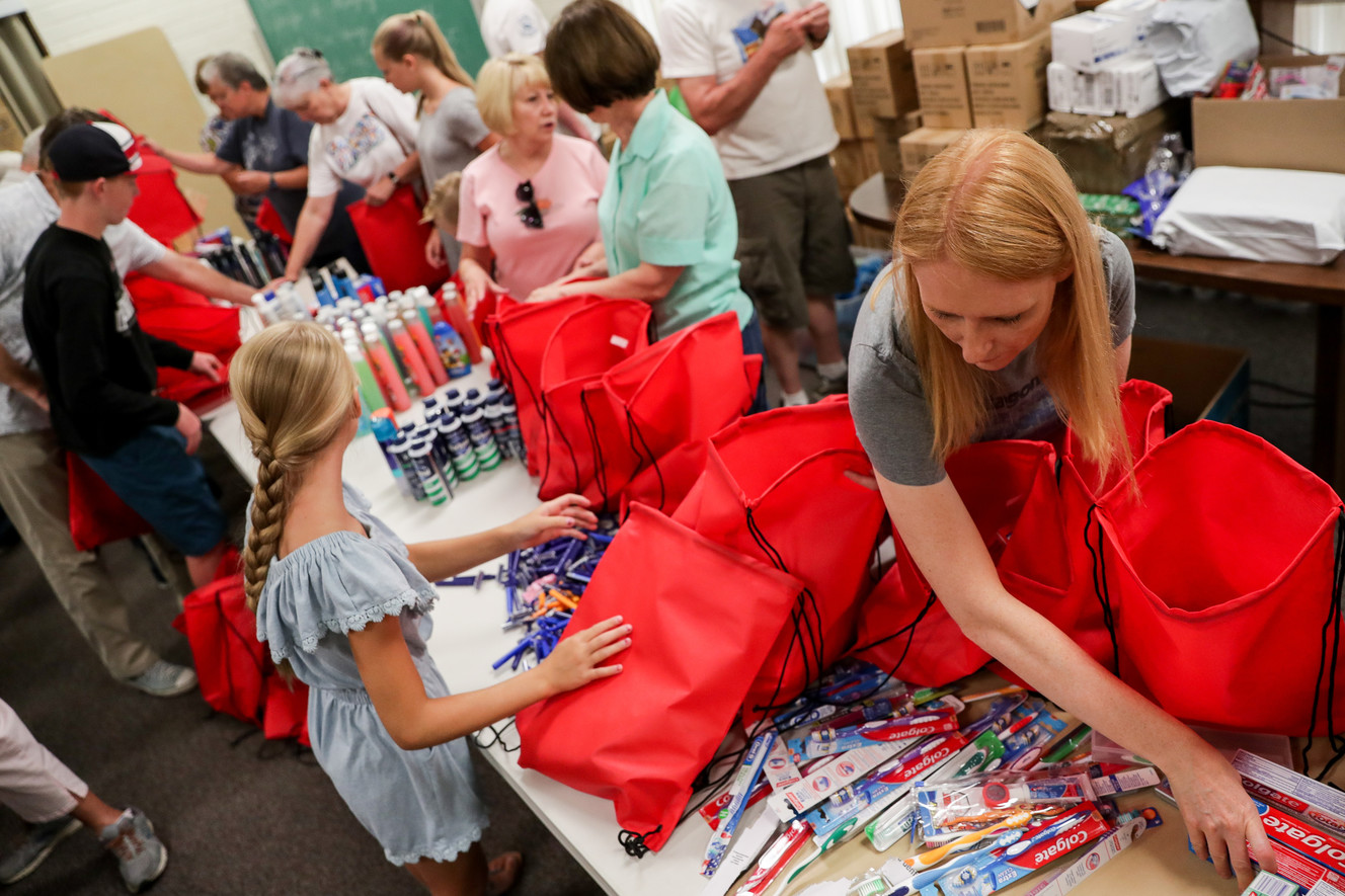 Lacy Gill, bottom right, and others assemble personal hygiene kits, including items such as toothpaste, shampoo and bodywash, to be distributed to homeless during a service project at an LDS meetinghouse in Millcreek on Saturday, July 28, 2018. Members of the Canyon Rim neighborhood of Millcreek gathered for three days of service projects. (Photo: Spenser Heaps, KSL)