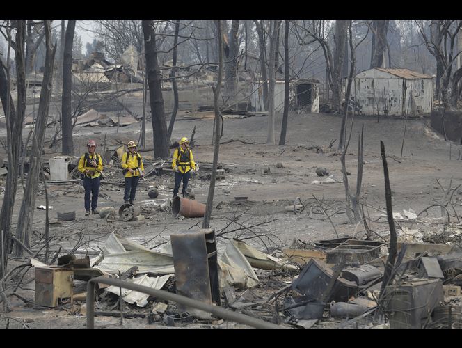 Thousands more flee wildfires as deadliest blaze slows down