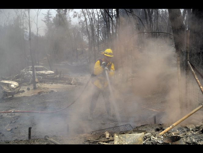 Thousands more flee wildfires as deadliest blaze slows down