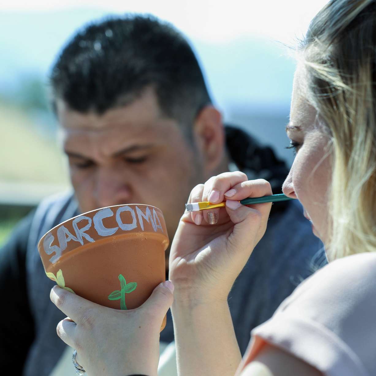 Nestor Cruz, back, and his wife, Sheila, join other sarcoma patients, physicians and caregivers at a sunflower planting party in honor of Sarcoma Awareness Month at the Huntsman Cancer Institute in Salt Lake City on Monday, July 30, 2018. Nestor Cruz has Liposarcoma, a rare type of cancer that begins in the fat cells. (Photo: Steve Griffin, KSL)
