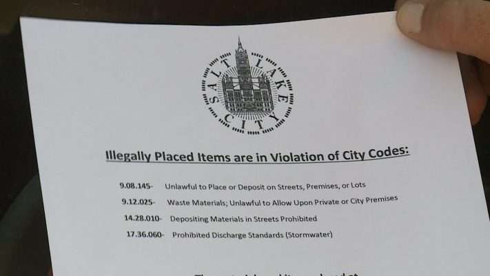 Salt Lake City workers with the Waste and Recycling Division deliver reminders about a new trash pickup program called "Call to Haul" on Tuesday, July 31, 2018. Trash piles have formed on several streets. Photo: Winston Armani, KSL TV