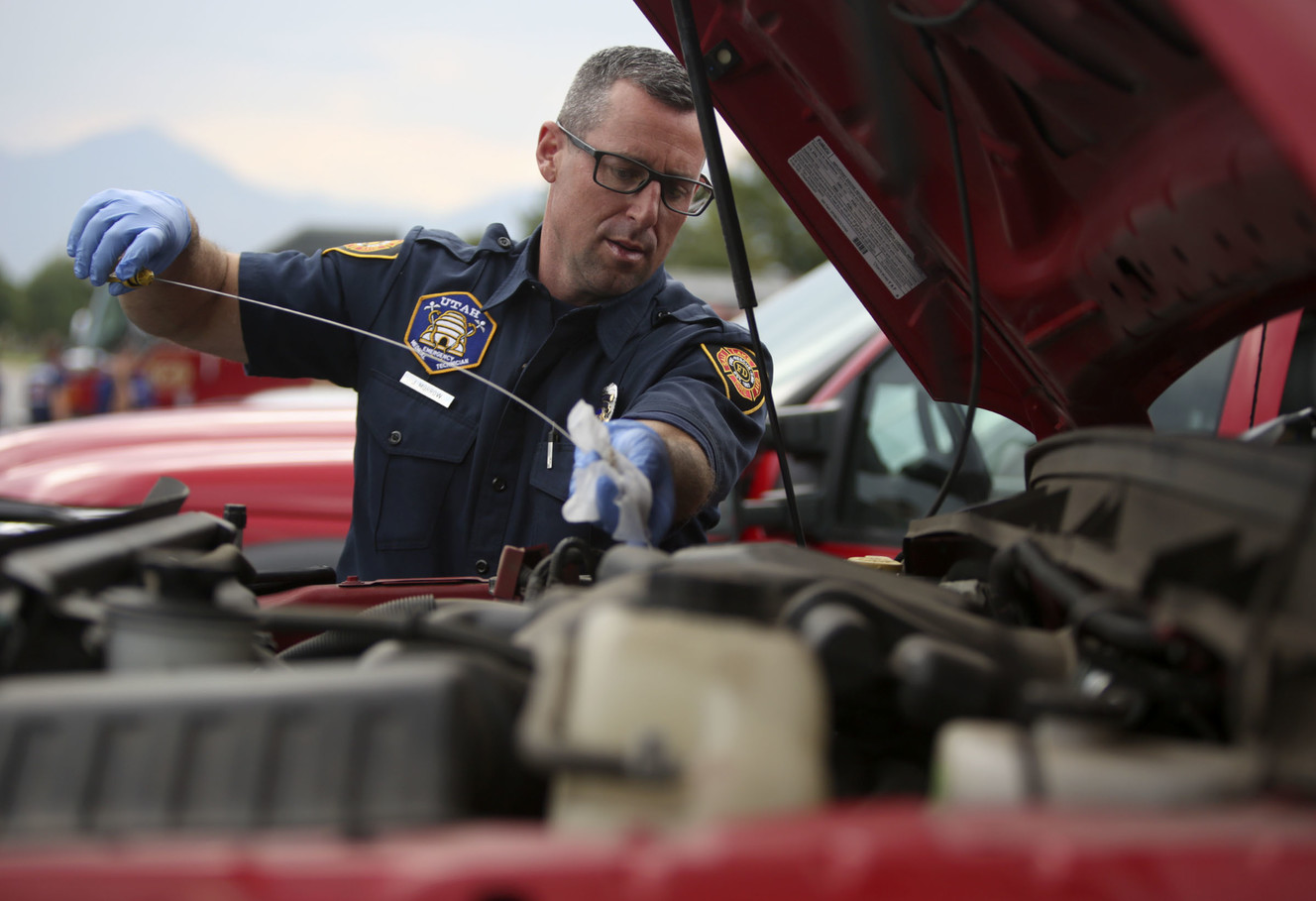 Salt Lake City fire engineer Justin Morrow checks fluid levels in a truck outside the Maverik Center in West Valley City before deploying to California to help fight the wildfires there on Thursday, Aug. 2, 2018. (Photo: Kristin Murphy, KSL)