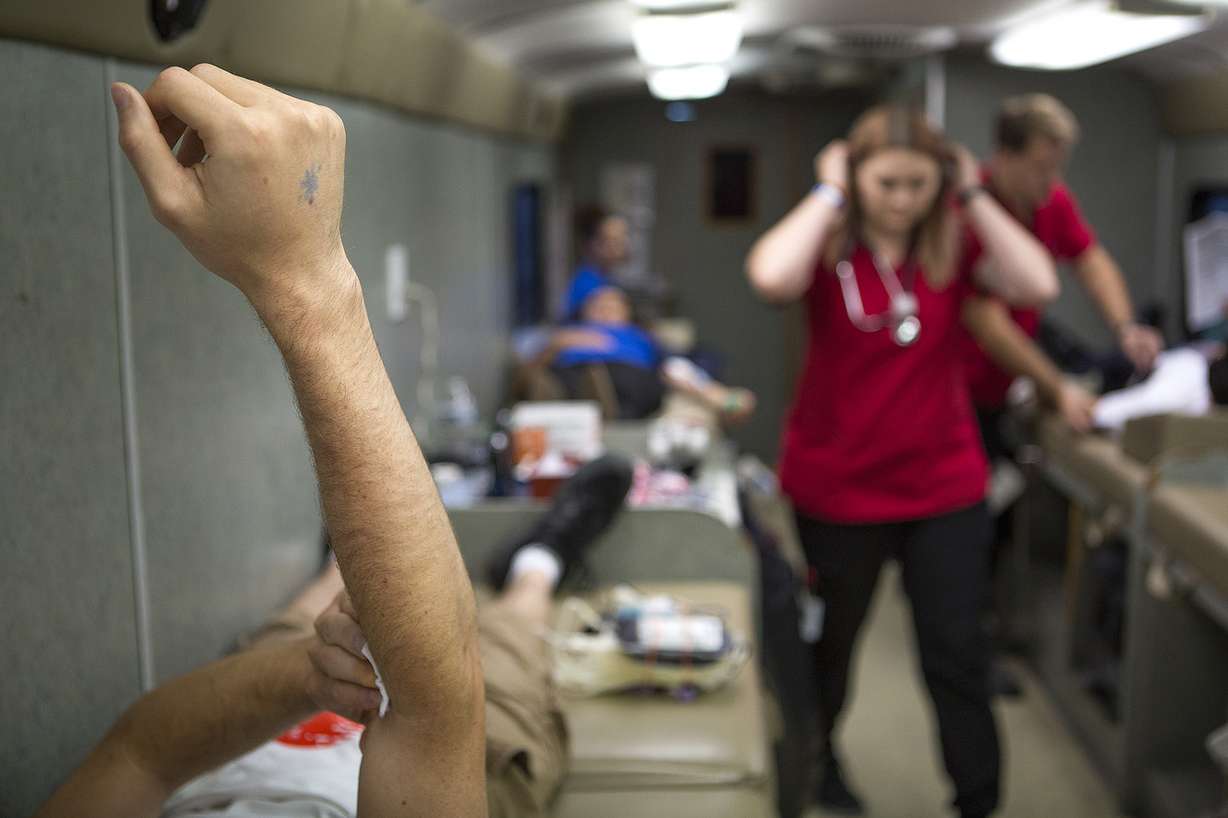 Jake Backues elevates his arm after giving blood in an American Red Cross bus in the parking lot of the World Mission Society Church of God in Salt Lake City on Sunday, Aug. 5, 2018. The church hosted a blood drive to combat a blood shortage in Utah hospitals. (Photo: James Wooldridge, KSL)