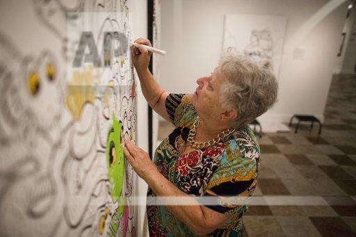 Georgia Roskelly, from American Fork, works on filling in a comic panel at the "Heroes and Villains" show at the Woodbury Art Museum on Tuesday, July 31, 2018, in Orem, Utah. "This appeals to all ages," Roskelly said about the show. (Evan Cobb, The Daily Herald via AP)