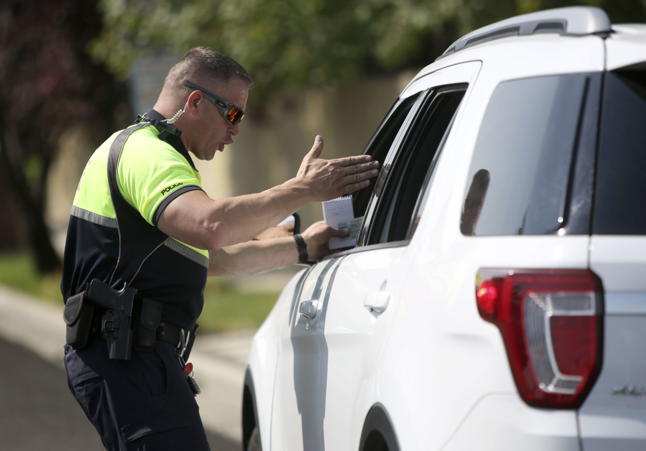 West Valley police officer Scott Folkers talks to a driver before issuing a citation during a crosswalk safety operation in West Valley City on Tuesday, Aug. 7, 2018. Traffic must stop and wait for pedestrians in a school zone crosswalk to get from curb to curb before proceeding. This is different from other crosswalks, where motorists have to wait for pedestrians to get to the other half of the road before proceeding. (Photo: Kristin Murphy, KSL)