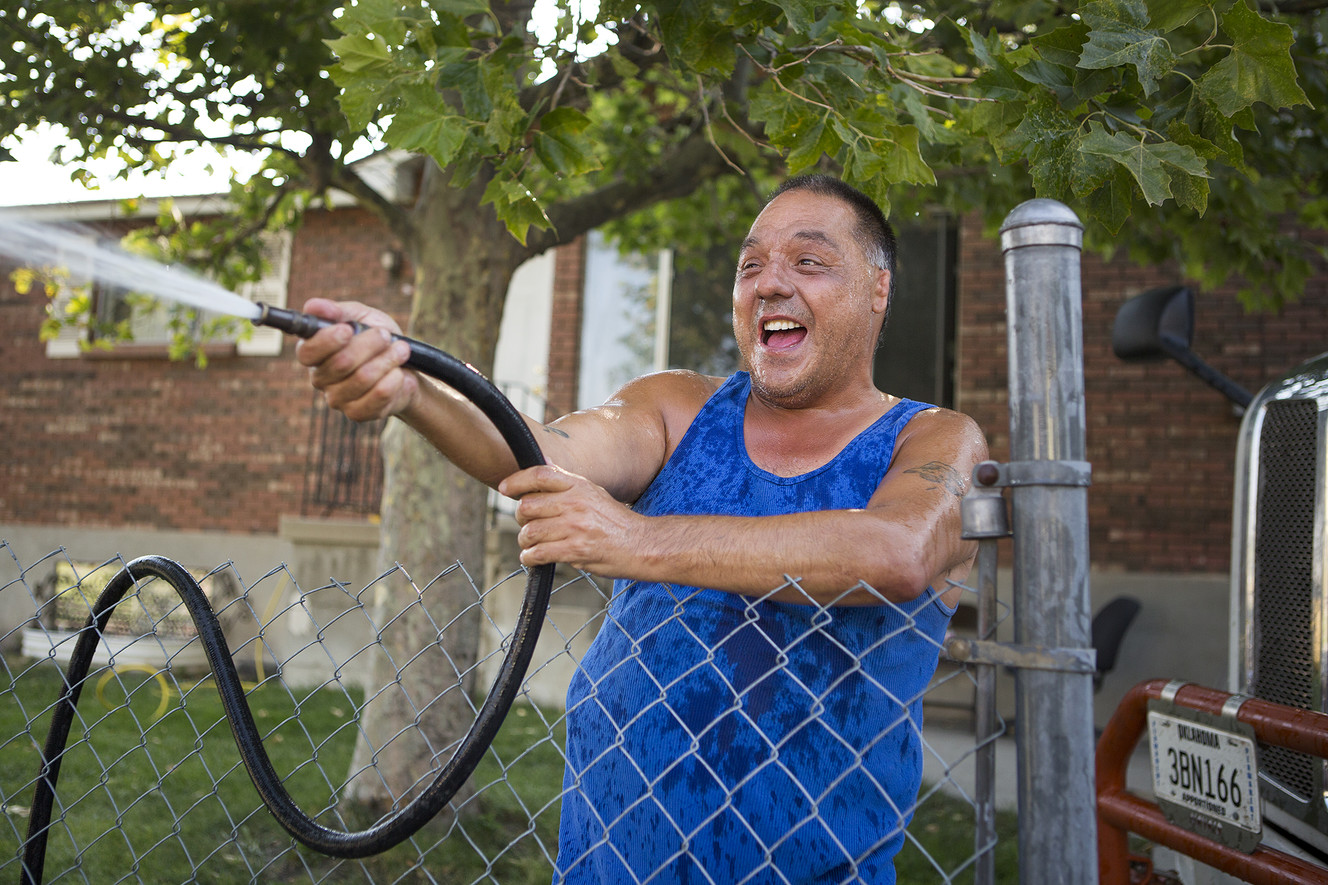 George Vigil sprays passers-by with a hose during a water parade put on by the Jordan Meadows Community Council, Westpointe Community Council and the Salt Lake City Police Department as part of the "Night Out Against Crime" in Salt Lake City on Tuesday, Aug. 7, 2018. (Photo: James Wooldridge, KSL)