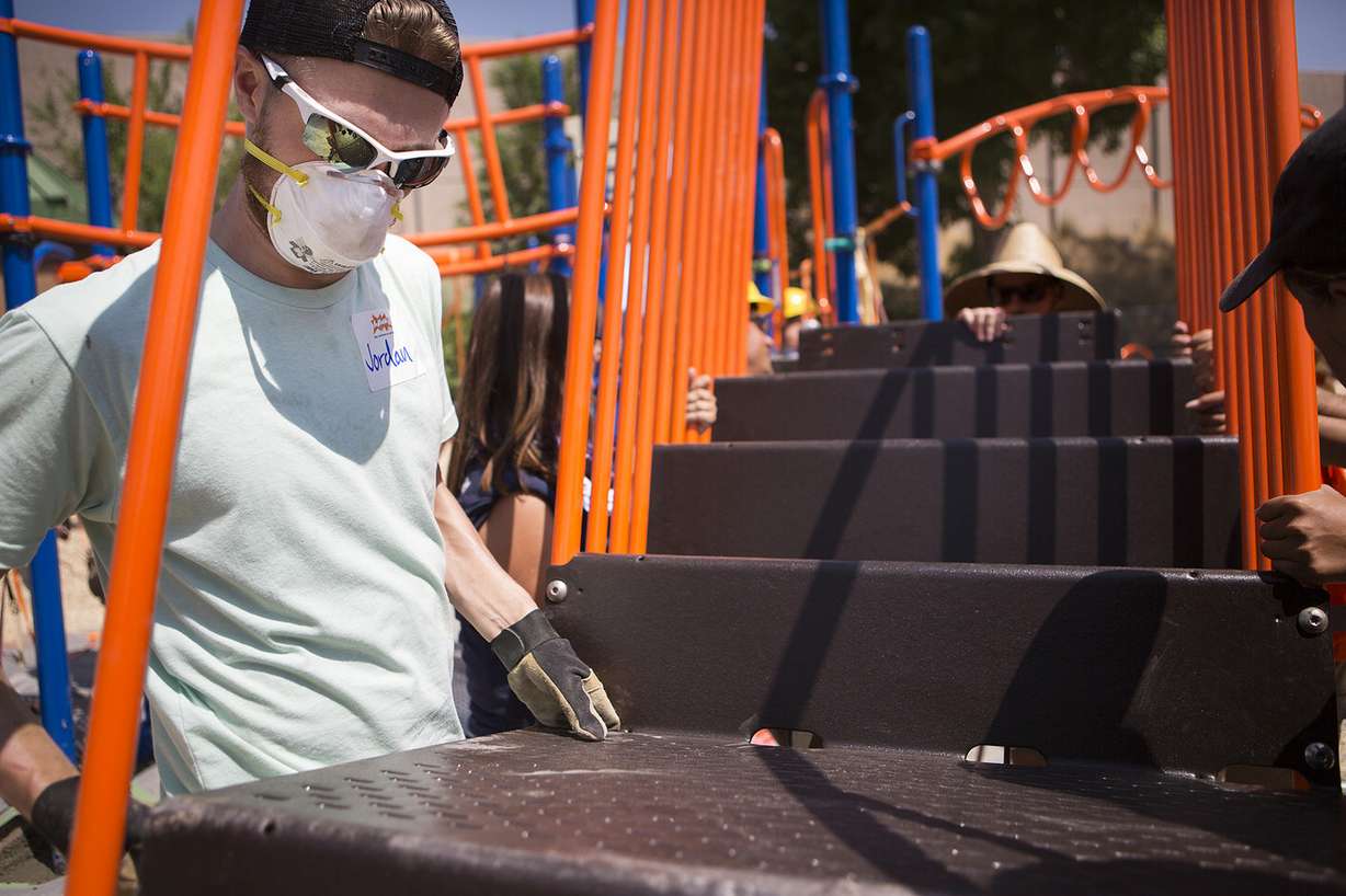 Jordan Demik helps carry a staircase as he and other volunteers build a new playground in South Salt Lake on Thursday, Aug. 9, 2018. The playground was based on drawings made by children in the community in June. (Photo: James Wooldridge, KSL)