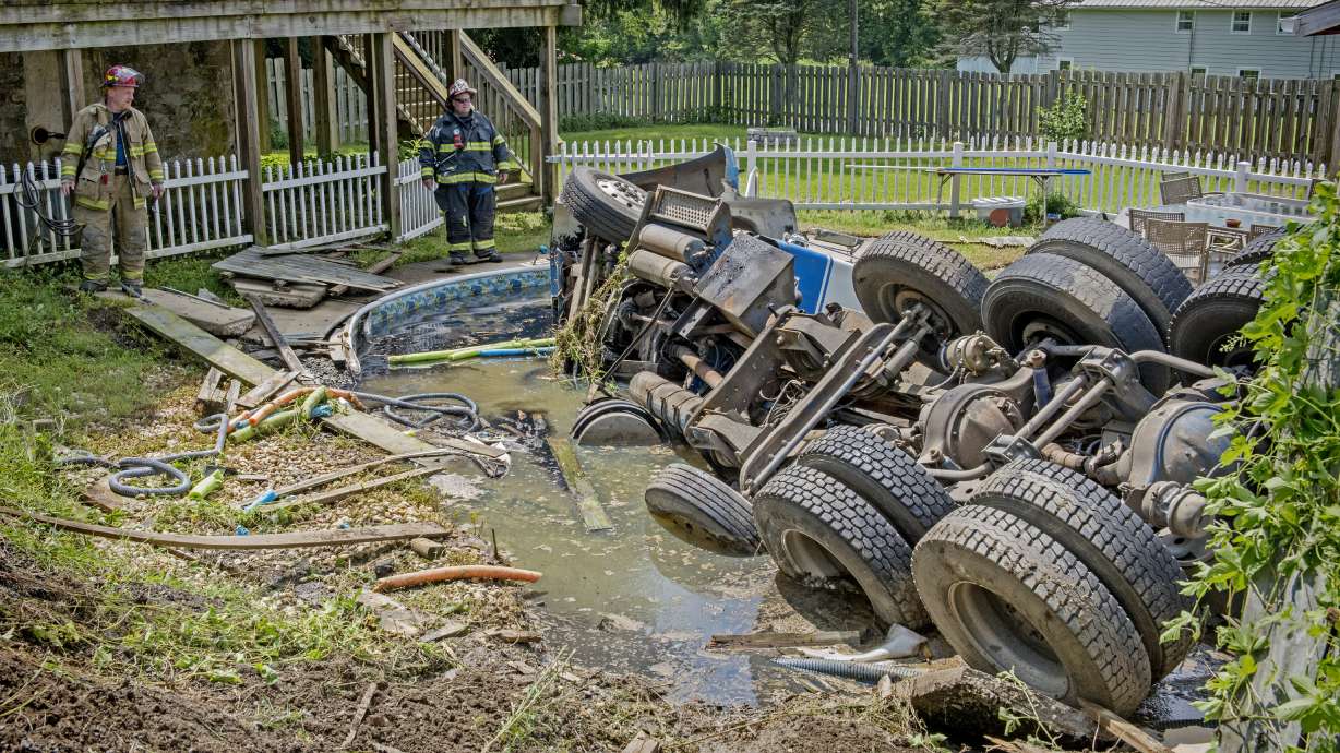 Crash leaves septic truck upside-down in backyard pool