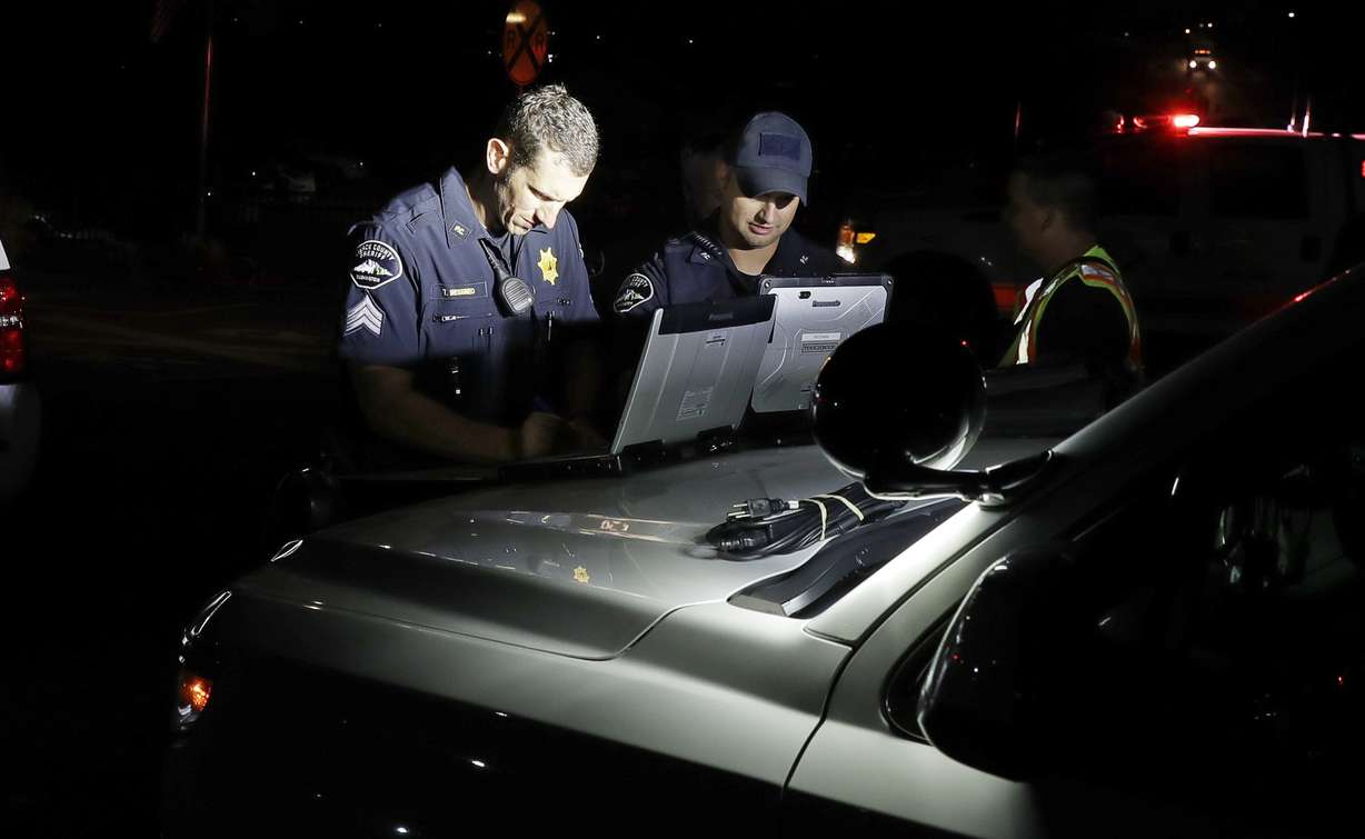 Law enforcement officials work at a staging area, Friday, Aug. 10, 2018, at the ferry terminal in Steilacoom, Wash., near where a Coast Guard spokeswoman said the agency was responding to a report of a smoke plume and possible plane crash. Earlier in the evening, officials at Seattle-Tacoma International Airport said an Alaska Airlines plane had been stolen and later crashed. (AP Photo/Ted S. Warren)