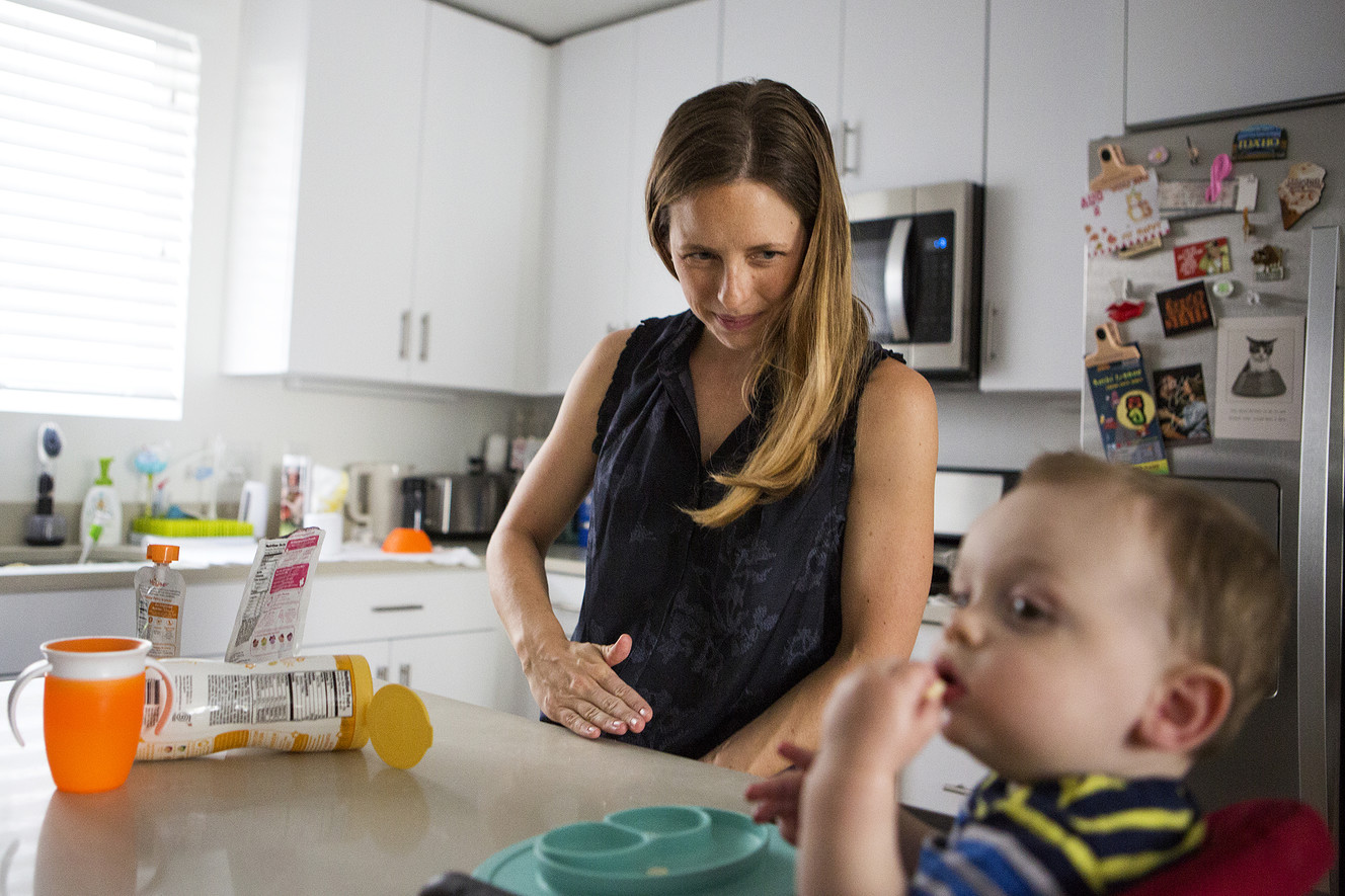 Jessica Page, an OB-GYN doctor, wipes crumbs off the counter while feeding her son, Patrick "Paddy" Schrager, 11 months, at their home in Salt Lake City on Friday, Aug. 10, 2018. A new study in the New England Journal of Medicine found that inducing labor at 39 weeks reduces the risk of emergency cesarean sections for first-time moms. (Photo: James Wooldridge, KSL)