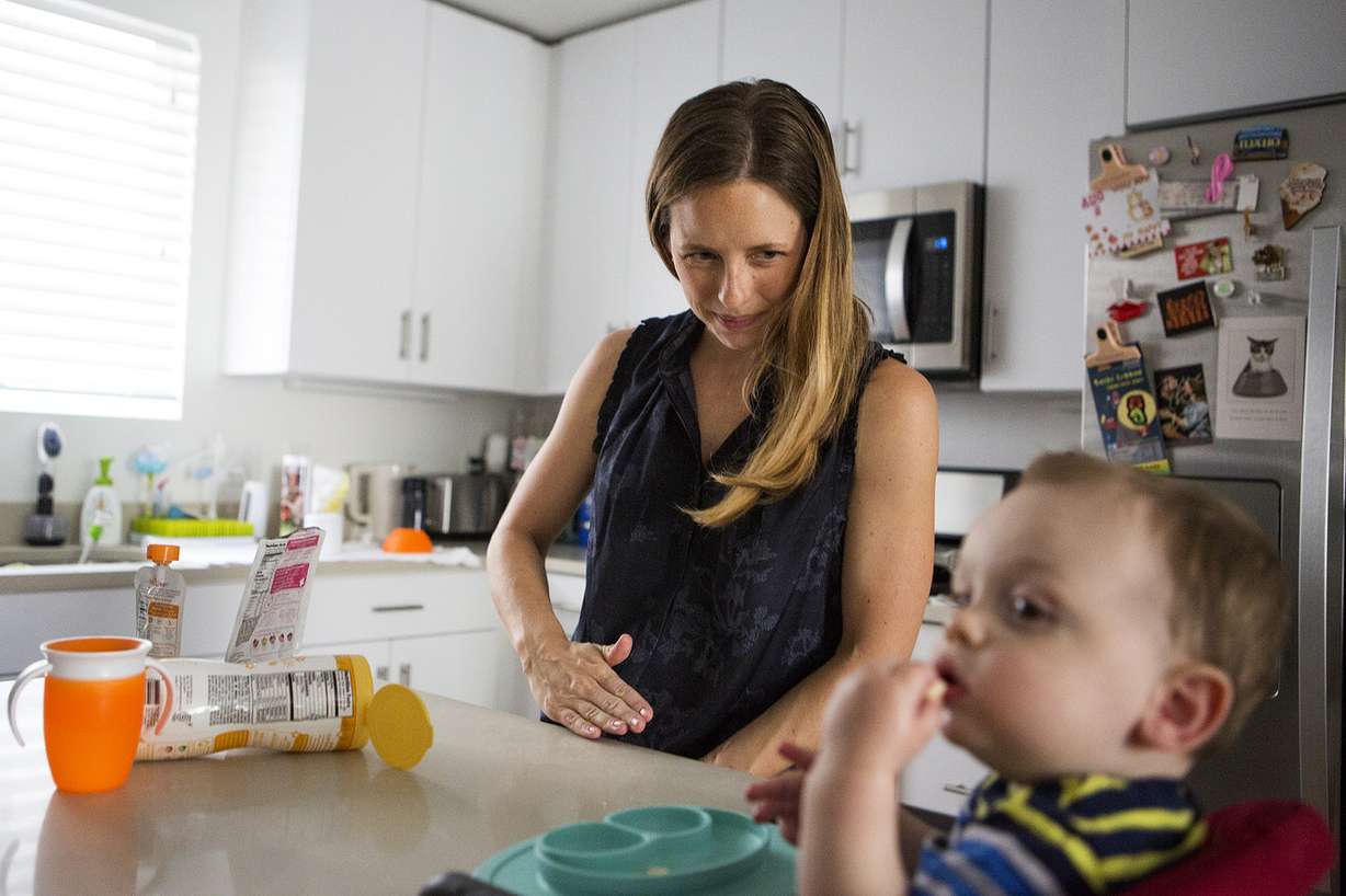 Jessica Page, an OB-GYN doctor, wipes crumbs off the counter while feeding her son, Patrick "Paddy" Schrager, 11 months, at their home in Salt Lake City on Friday, Aug. 10, 2018. A new study in the New England Journal of Medicine found that inducing labor at 39 weeks reduces the risk of emergency cesarean sections for first-time moms. (Photo: James Wooldridge, KSL)